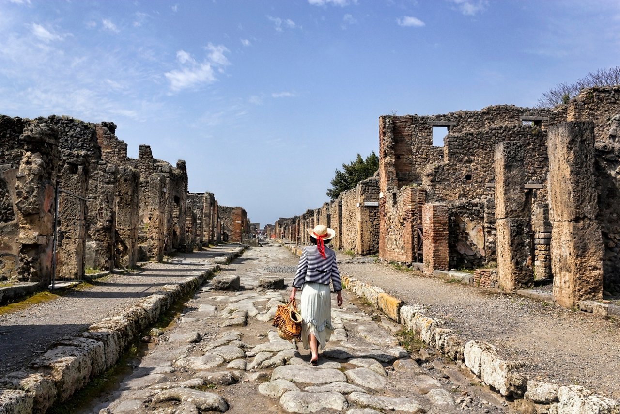 Una mujer camina entre las antiguas ruinas de Pompeya, explorando la rica historia arqueológica de Italia | MSC Cruises