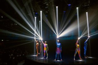 Eine lebendige Live-Performance mit Tänzern, die von dramatischen Lichtern auf der Bühne beleuchtet werden | MSC Cruises