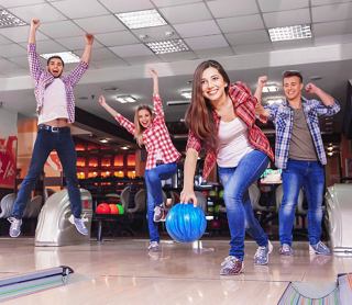 Un groupe d'amis célèbre joyeusement en jouant au bowling ensemble dans une zone de divertissement animée | MSC Cruises
