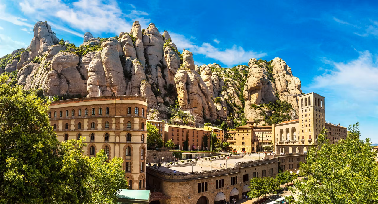 Une vue époustouflante d'un monastère niché parmi des montagnes rocheuses sous un ciel bleu éclatant à Tarragone, Espagne | MSC Croisières