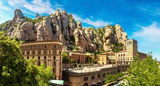 A stunning view of a monastery nestled among rocky mountains under a bright blue sky in Tarragona, Spain | MSC Cruises