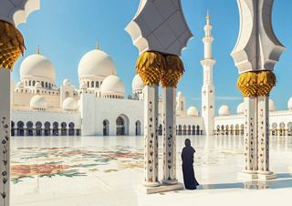 A woman stands gracefully among the stunning architecture of Sheikh Zayed Mosque in Abu Dhabi | MSC Cruises