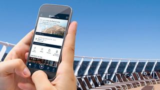 A hand holding a smartphone displaying the MSC for Me app while enjoying a sunny day on deck in Barcelona | MSC Cruises