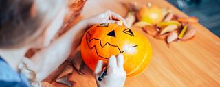 Ein Kind dekoriert einen Kürbis mit einem Stift, feiert Halloween und genießt festliche Unterhaltung an Bord | MSC Cruises