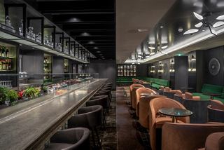 A stylish bar setting featuring a mixology counter and comfortable seating, inviting guests to unwind and enjoy | MSC Cruises
