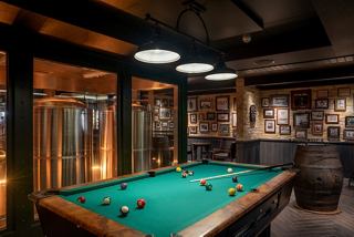 A stylish billiard table in a warm bar setting, inviting guests to enjoy games and socialising | MSC Cruises