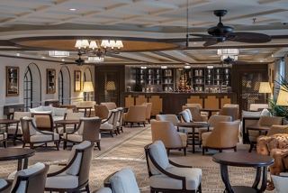 A welcoming bar and lounge area with elegant seating and a stylish counter for socialising and relaxation | MSC Cruises