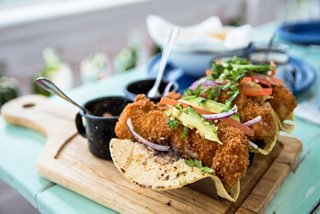Ein Teller mit köstlichen Fisch-Tacos, garniert mit frischen Zutaten | MSC Cruises