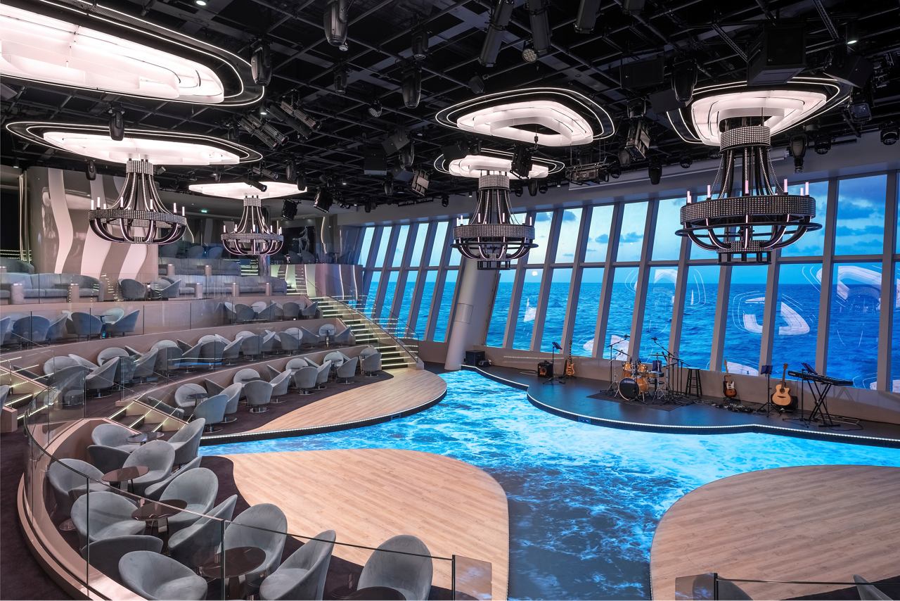 A spacious entertainment area featuring comfortable seating and a large stage, designed for memorable performances | MSC Cruises