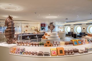 A welcoming café with a friendly staff member ready to serve delicious sweets and treats | MSC Cruises