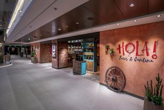 La entrada a HOLA! Tacos & Cantina, con un letrero acogedor y un diseño moderno | MSC Cruceros