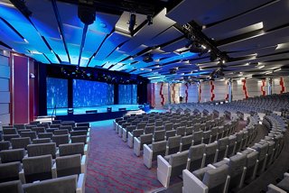 A spacious theater with a stage and comfortable seating for entertainment | MSC Cruises