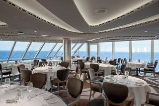 Guests enjoy a dining experience in the panoramic MSC Yacht Club Restaurant with stunning sea views | MSC Cruises