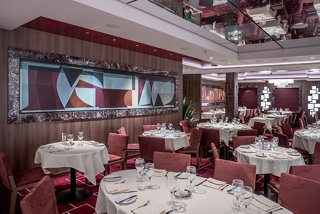 An inviting dining area with elegantly set tables and tasteful artwork, perfect for enjoying fine cuisine | MSC Cruises