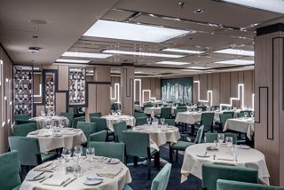 Elegant dining space with tables set for guests, featuring a warm atmosphere and stylish decor | MSC Cruises