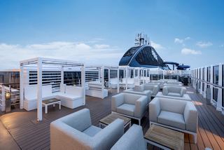 Outdoor bar with seating on MSC Seascape at dusk | MSC Cruises