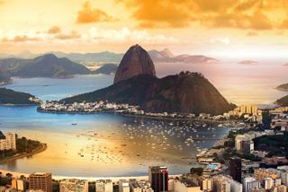 Panoramic view of Rio de Janeiro featuring mountains and the sea during sunset | MSC Cruises