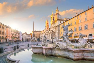 Un beau coucher de soleil sur la Piazza Navona, mettant en valeur la fontaine emblématique au cœur de Rome | MSC Croisières