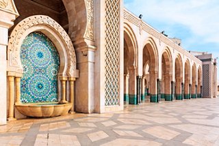 A beautiful courtyard in Casablanca featuring intricate mosaics, arches, and a serene fountain under a clear sky | MSC Cruises