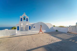 Une vue pittoresque d'un bâtiment blanc avec un dôme bleu surplombant la mer à Santorin, Grèce | MSC Croisières