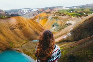 A woman gazes at the stunning Landmannalaugar valley in Iceland, surrounded by vibrant landscapes | MSC Cruises