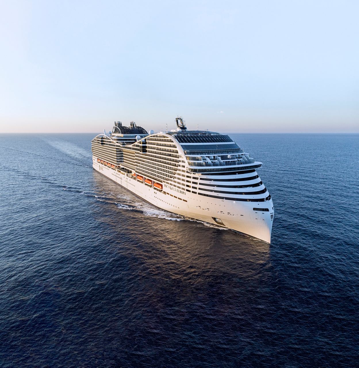 The MSC World Europa ship sails through calm waters, surrounded by sky and sea | MSC Cruises