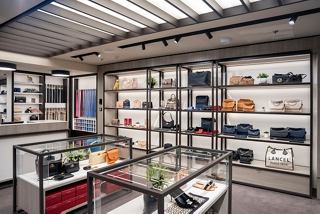 A stylish shop interior on MSC World Europa showcasing luxury accessories and bags on display shelves | MSC Cruises