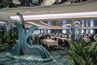 A beautiful restaurant interior featuring a striking sculpture and lush plants, creating a welcoming atmosphere | MSC Cruises