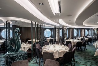 Dining area in The Green Wave Restaurant aboard MSC Seascape, featuring tables arranged with sea views | MSC Cruises