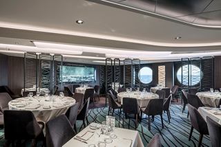 The modern restaurant features a cozy atmosphere with tables and a view of the sea | MSC Cruises