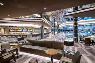 A stylish and spacious lounge area with comfortable seating and large windows overlooking the sea | MSC Cruises