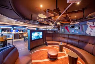 A welcoming sports bar with comfortable seating and a large screen for entertainment | MSC Cruises