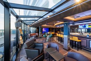 A welcoming sports bar with comfortable seating, large windows, and a vibrant atmosphere on MSC Seascape | MSC Cruises