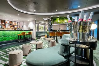 A stylish cocktail bar featuring comfortable seating, vibrant artwork, and a welcoming ambience for guests to enjoy | MSC Cruises