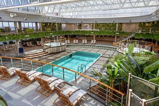 A serene pool area surrounded by comfortable loungers and lush greenery invites relaxation and enjoyment | MSC Cruises