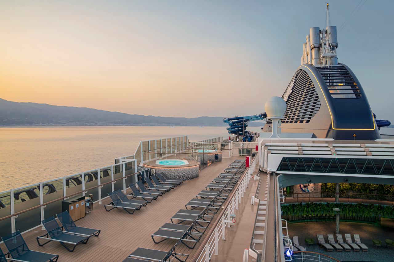 A serene view of the MSC Seascape deck featuring sunbeds, a whirlpool bath, and the sea in the background | MSC Cruises