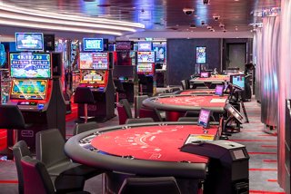 A lively casino area featuring gaming tables and slot machines, inviting guests to enjoy thrilling entertainment | MSC Cruises