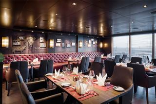 A warm and inviting dining area in the Butcher's Cut speciality restaurant aboard the MSC Seascape | MSC Cruises