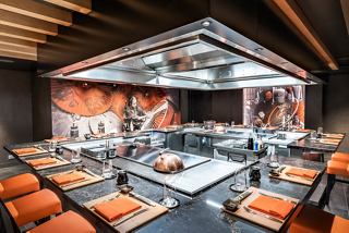 A modern dining area with vibrant seating and a central grill, perfect for enjoying unique culinary experiences | MSC Cruises