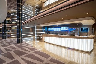 The welcoming reception area features a sleek desk and screens, inviting guests to explore MSC Seascape adventures | MSC Cruises