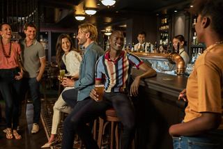 Un groupe divers d'amis profite de boissons ensemble dans un bar animé sur le MSC World Europa | MSC Cruises
