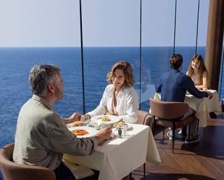 A couple enjoys a delightful lunch with sea views at Il Mercato Buffet on MSC World Europa | MSC Cruises