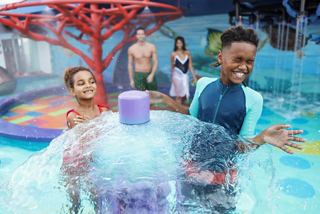 Niños disfrutando de juegos de agua en el parque acuático Aurora Borealis, con un entorno vibrante que crea momentos alegres | MSC Cruceros