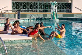 A joyful group of friends enjoying time together by the pool on MSC World Europa | MSC Cruises