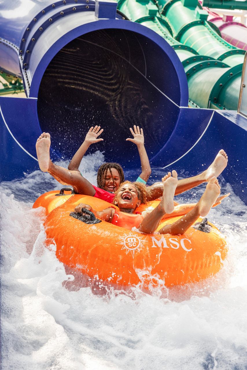 Families enjoying a thrilling ride together in an inflatable raft at the Aurora Borealis Aquapark | MSC Cruises