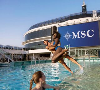 Des amis sautent dans la piscine du MSC World Europa, profitant du soleil et de la joie | MSC Croisières