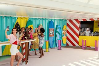 A group of friends enjoying drinks and taking selfies at the vibrant Surfer's Bar on MSC World Europa | MSC Cruises