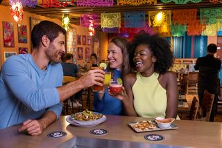 Des amis profitent de cocktails et d'un repas dans un restaurant latino-américain animé à bord du MSC World Europa | MSC Croisières