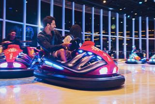 Friends enjoying bumper cars in the MSC Sportplex, creating joyful memories together at night | MSC Cruises