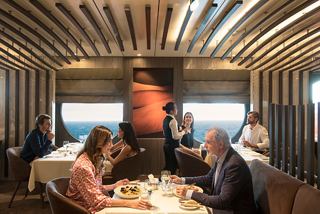 A couple enjoys a meal in Les Dunes Restaurant while attentive staff provide excellent service and a view of the sea | MSC Cruises